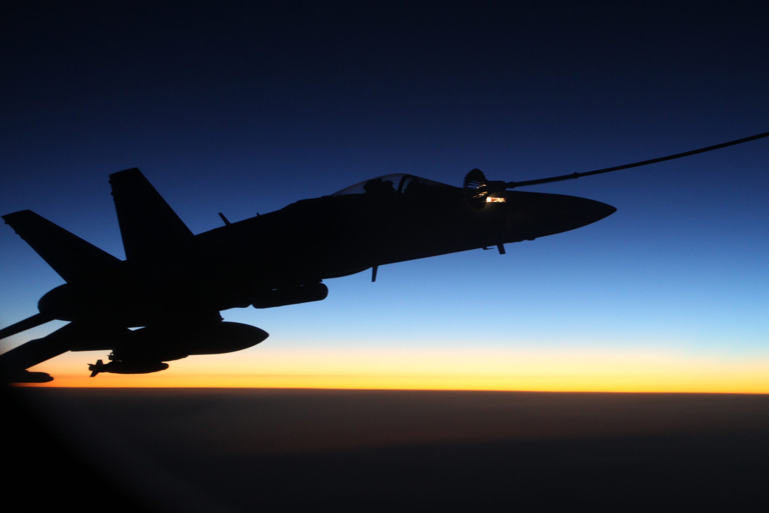 An F/A-18A Hornet from Australia's Air Task Group refuels at sunset from a Royal Australian Air Force KC-30A Multi Role Tanker Transport aircraft during the first mission of Operation OKRA to be flown over Syria. *** Local Caption *** The Australian Air Task Group has conducted its first operational mission in Syria. Two F/A18A Hornets, the KC-30A air-to-air refuelling aircraft and the E-7A Airborne Early Warning and Control aircraft worked together during the mission. The mission provided on-call interdiction and dynamic targeting support.